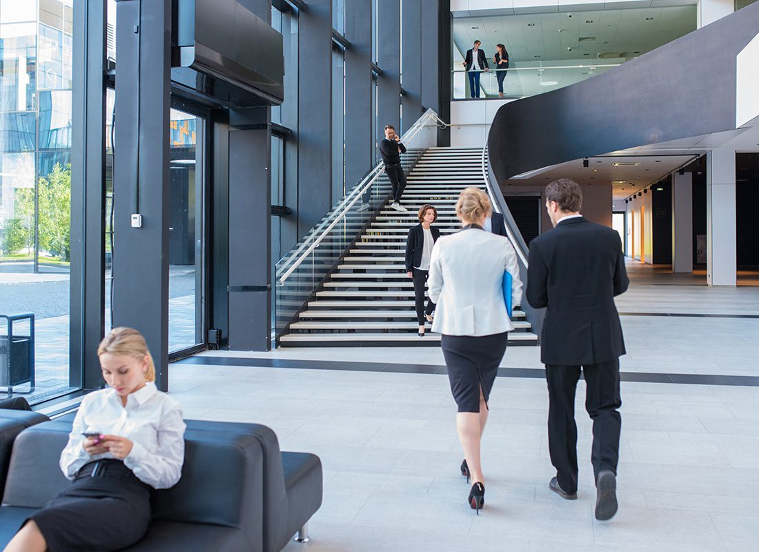 About Our Agency - Business Professionals Walking Through Modern Lobby